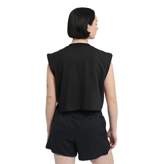 Person wearing a black sleeveless top and shorts on a white background