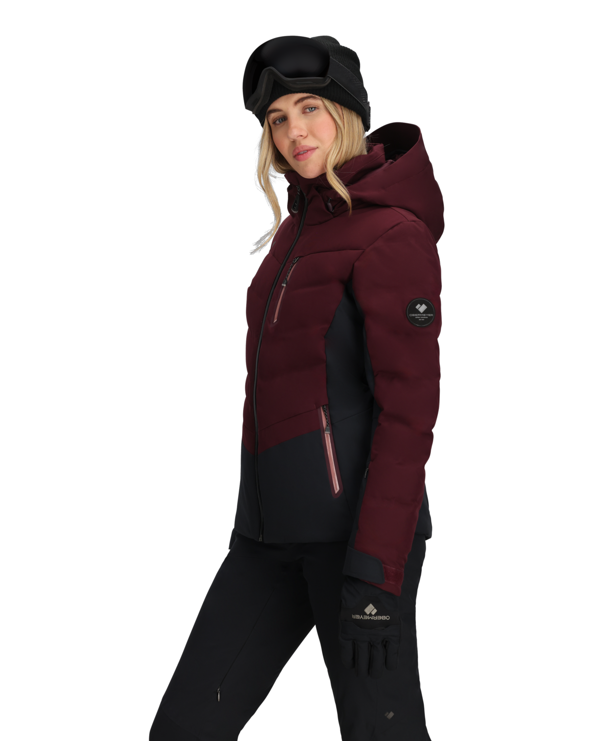 Person wearing a maroon and black winter jacket with a hood on a white background