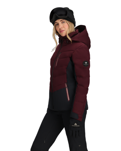 Person wearing a maroon and black winter jacket with a hood on a white background