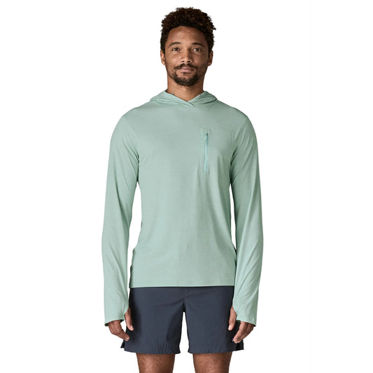 Man wearing a light green hoodie and navy shorts on a white background