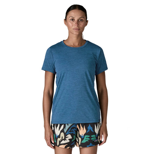 Woman wearing a blue t-shirt and patterned shorts on a white background